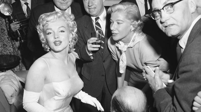 Marilyn Monroe posing in a crowd in black and white