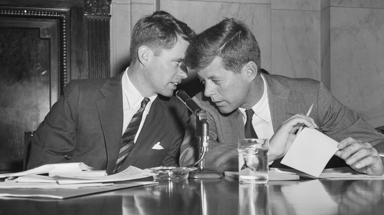 Robert F. Kennedy whispers to John F. Kennedy