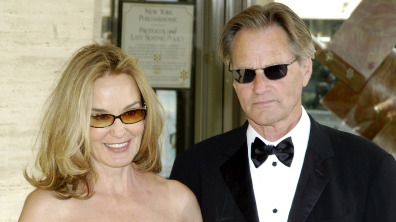 Jessica Lange and Sam Shepard wearing sunglasses looking off camera