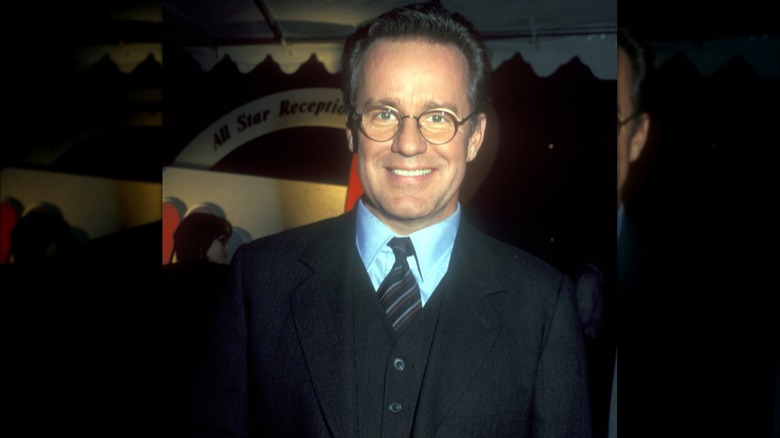 Phil Hartman smiling wearing glasses