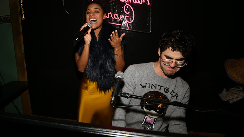 Darren Criss playing piano and Ariana DeBose singing