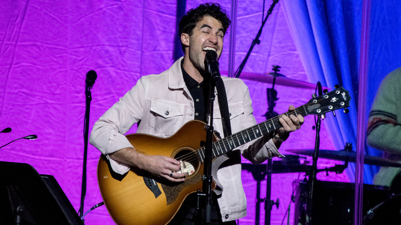 Darren Criss playing guitar and singing