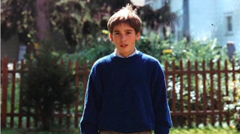 David Muir as a teenager in front of a fence