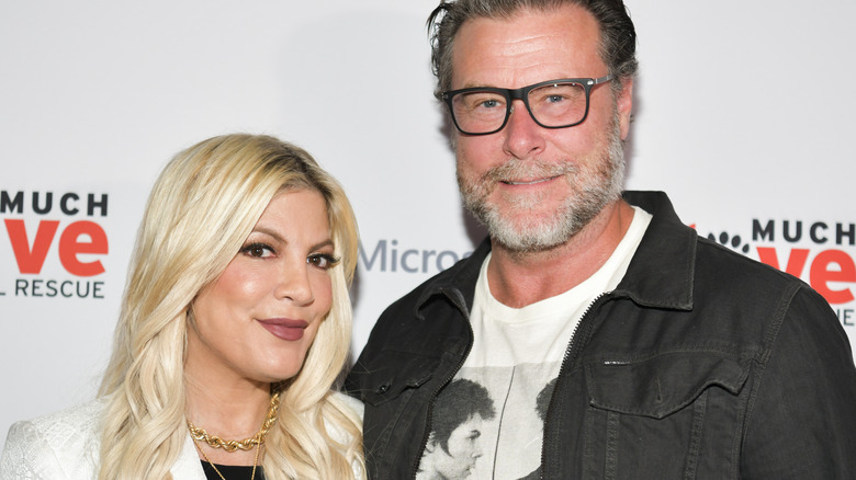 Dean McDermott and Tori Spelling smiling for cameras at an event 