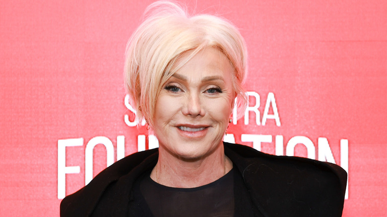 Deborra-Lee Furness posing in front of a pink background