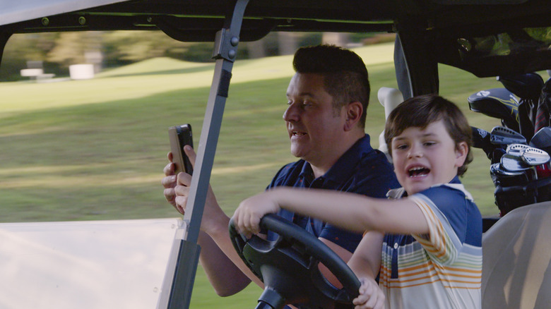 Jay DeMarcus and son in a golf cart