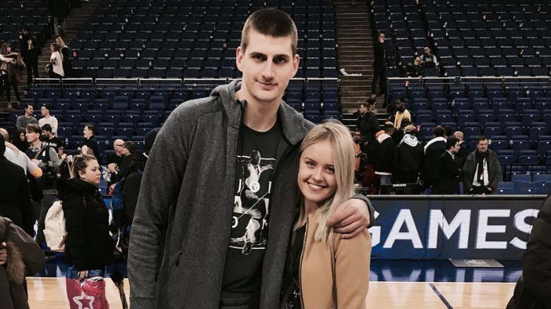 Nikola Jokic and Natalija Jokic pose on a basketball court