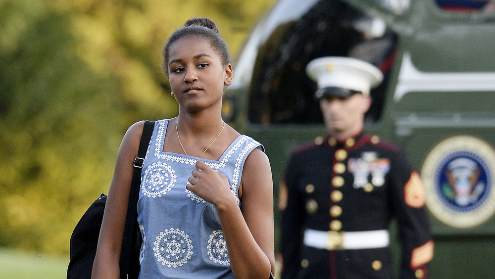 Sasha Obama walking with a U.S. soldier behind her