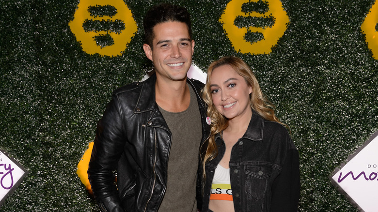 Brandi Cyrus and Wells Adams in black jackets