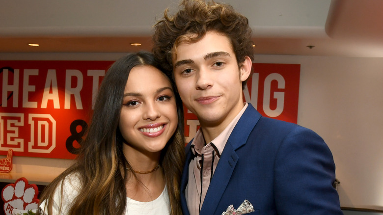 Olivia Rodrigo and Joshua Bassett pose side-by-side at an event