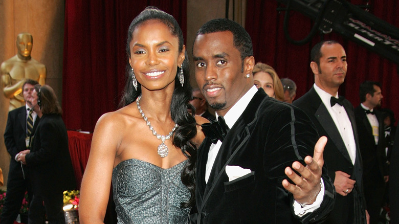 Kim Porter smiling, Diddy with his arm out