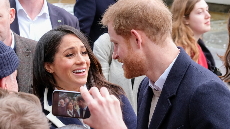 Meghan Markle and Prince Harry talk to each other among a crowd