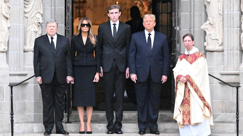 Barron Trump standing between Melania and Donald Trump