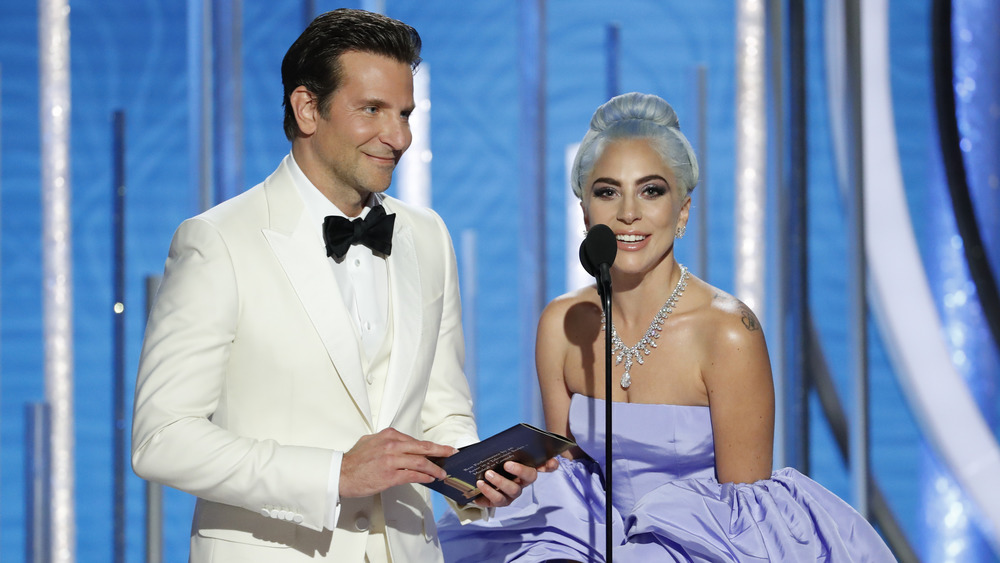 Bradley Cooper and Lady Gaga talking into a microphone together