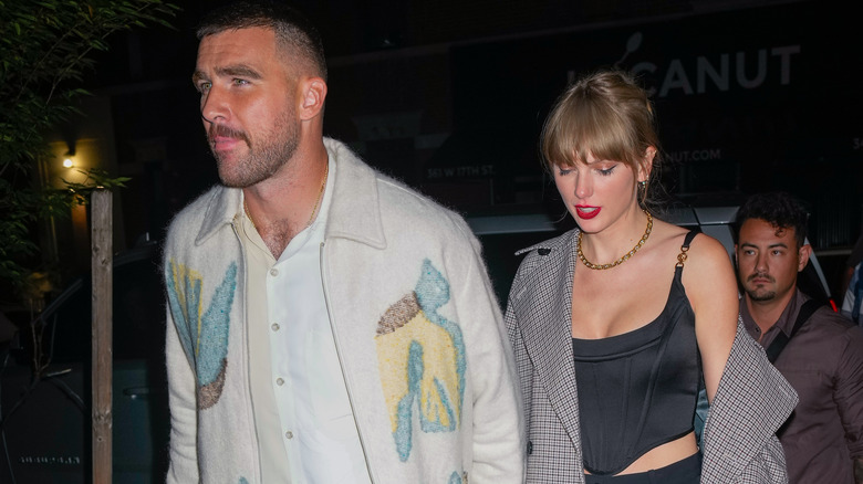 Travis Kelce, Taylor Swift outdoors at night