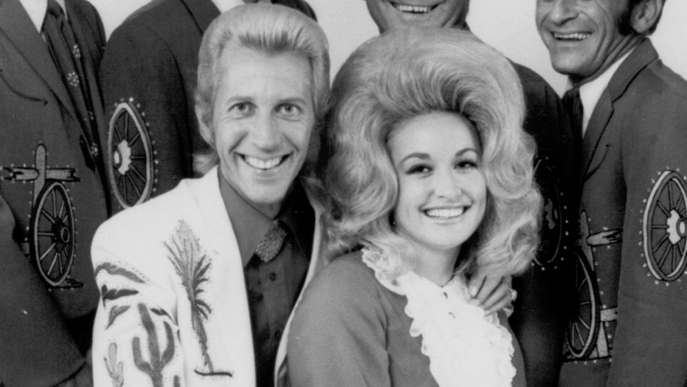 Porter Wagoner and Dolly Parton, both young, sitting together