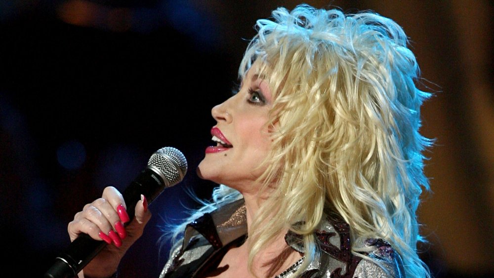 Dolly Parton singing into microphone, profile view