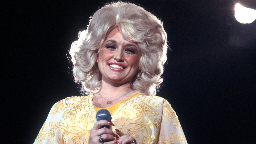 Young Dolly Parton smiling on stage