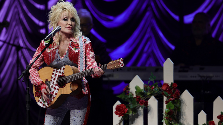 Dolly Parton plays guitar on stage