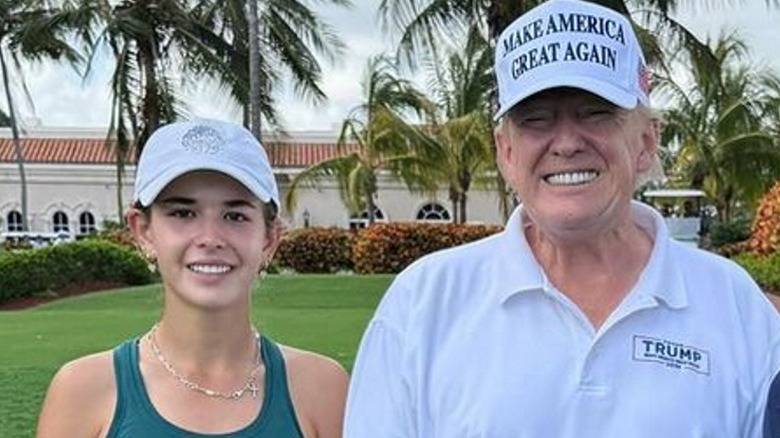 Kai Trump and Donald Trump pose on a golf course