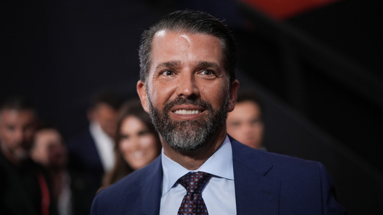 Donald Trump Jr. grinning in a suit