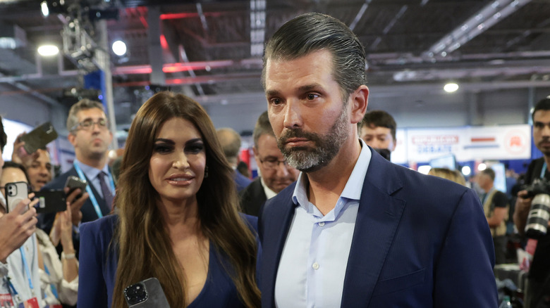 Kimberly Guilfoyle and Donald Trump Jr. walking at a 2023 political event