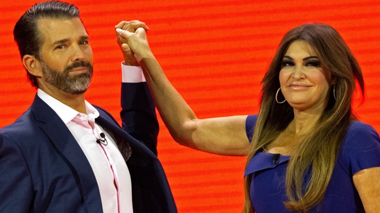 Donald Trump Jr. and Kimberly Guilfoyle on stage holding hands in air