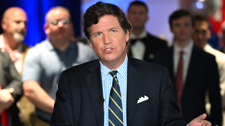 Tucker Carlson at a desk