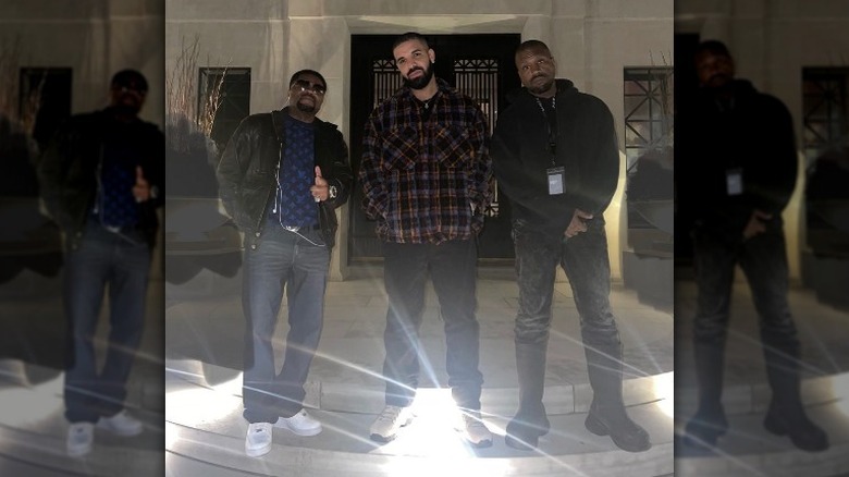 Drake posing with Kanye and another person