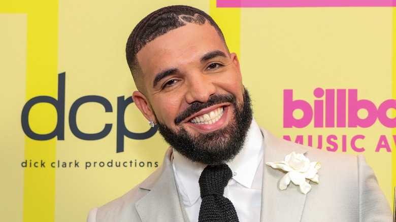 Drake smiling in a suit