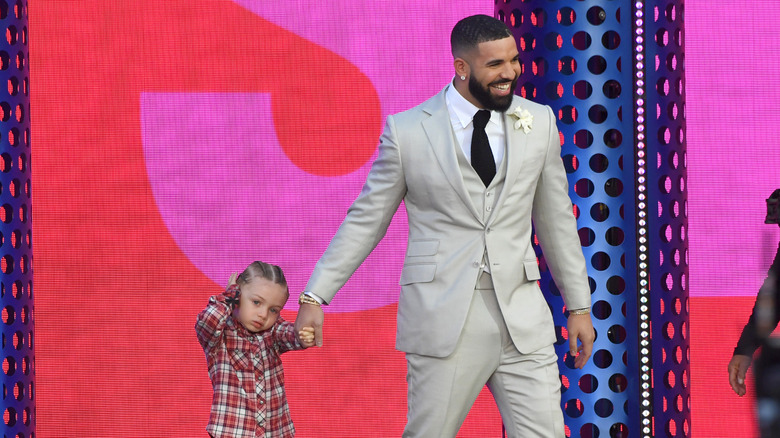 Drake holds Adonis' hand