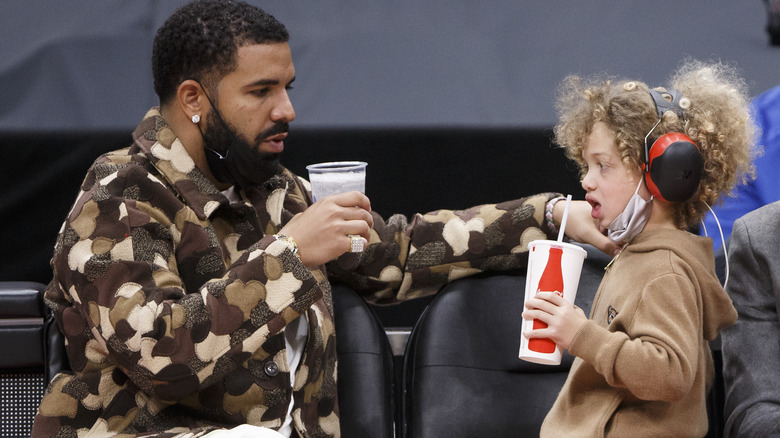 Drake and his son drinking beverages