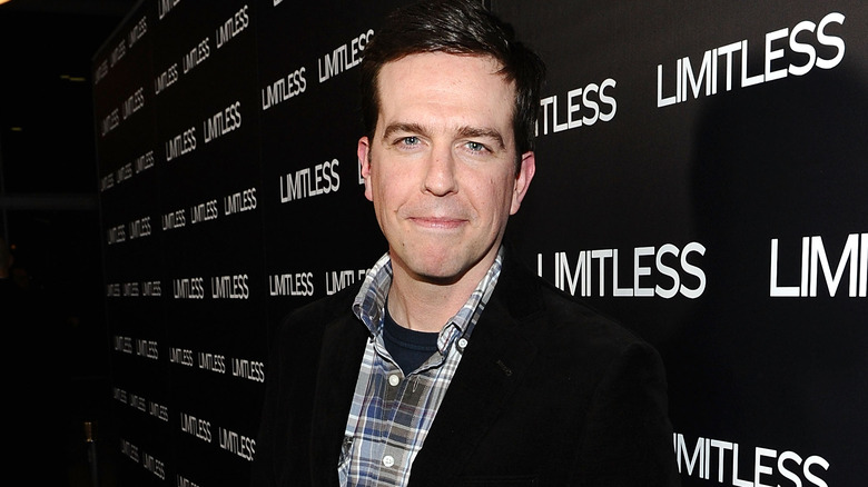 Ed Helms smiling, plaid shirt