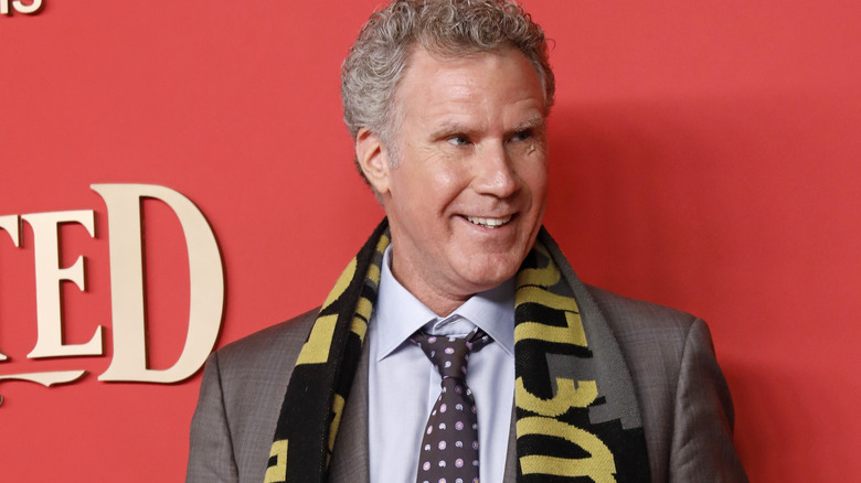 Will Ferrell posing cheerfully in scarf