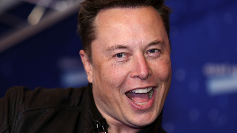 Elon Musk laughing slicked back hair