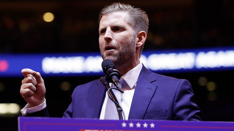 Eric Trump speaking into a mic at a Trump rally