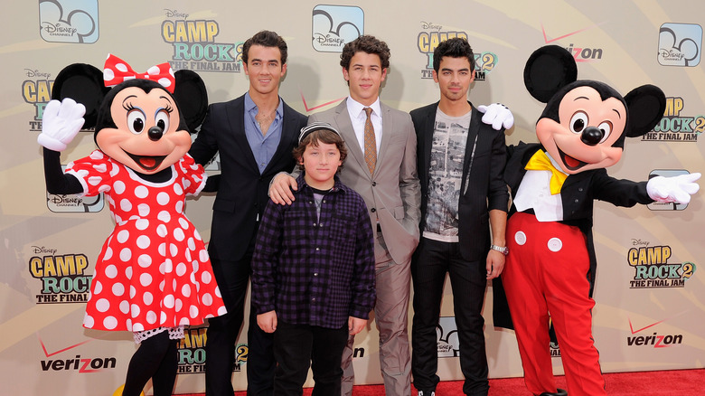 Jonas brothers with Disney characters