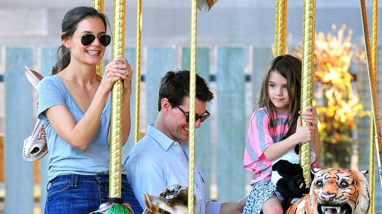 Katie Holmes laughing on carousel with Tom Cruise and Suri Cruise