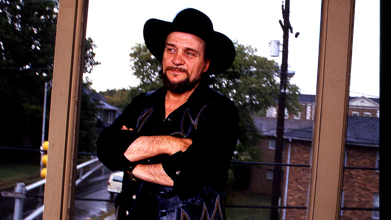 Waylon Jennings posing in front of a window