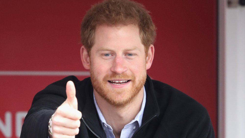 Prince Harry dressed casually and giving a thumbs up