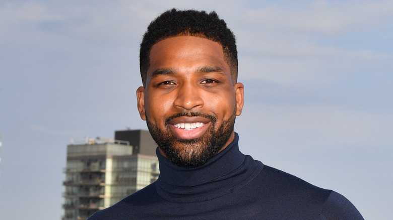 Tristan Thompson smiles for a photo in front of a building