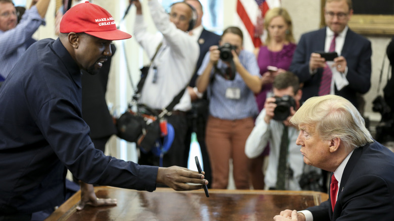 Kanye West showing phone to Donald Trump