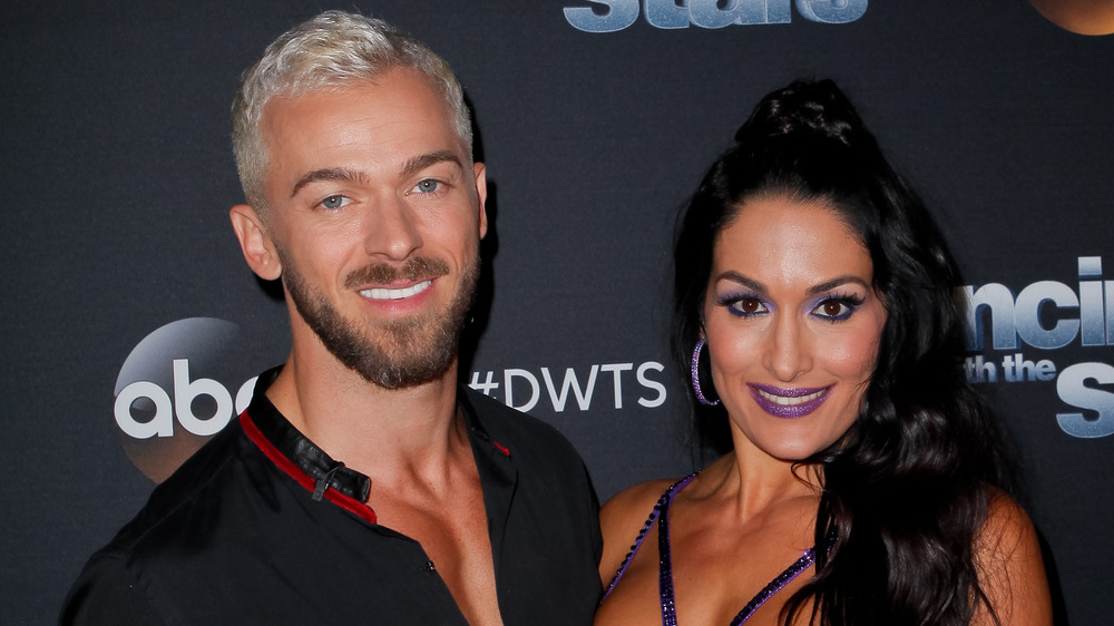 Artem Chigvintsev and Nikki Bella smiling