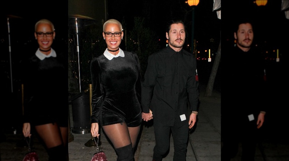 Amber Rose and Valentin Chmerkovskiy smiling and holding hands 