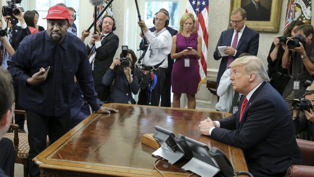 Kanye West wearing a MAGA hat with Donald Trump in the oval office