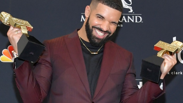 Drake grins and poses with his Billboard music awards