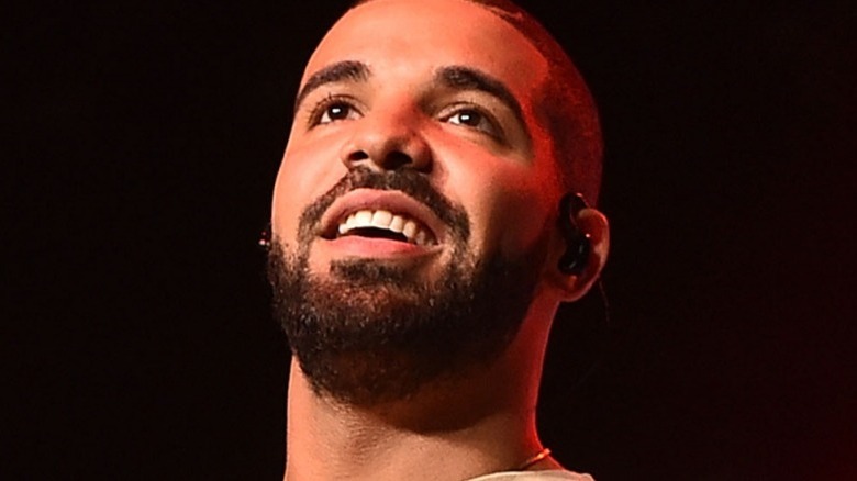 Drake smiles and looks up as he performs on stage