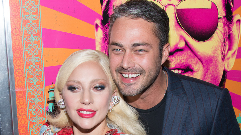 Lady Gaga and Taylor Kinney smiling together on the red carpet