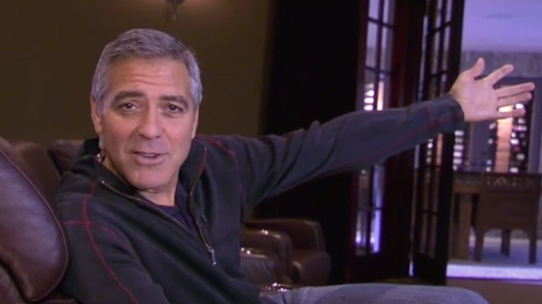 George Clooney holding his arm out