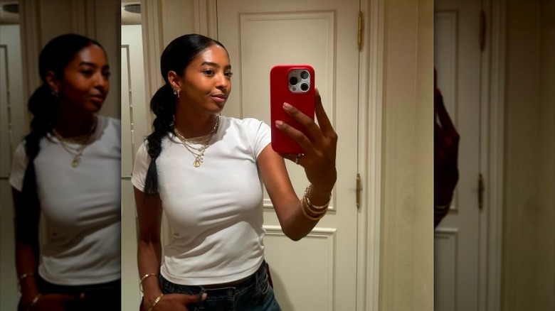 Natalia Bryant takes mirror selfie in white T-shirt